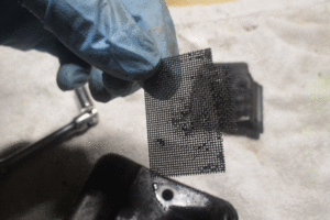 Clean the spark arrestor screen to help solve chainsaw starting problems. 